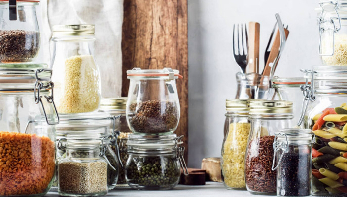 Image of rice pasta and other staples in containers in a kitchen pantry