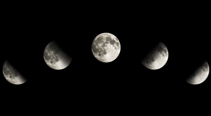 Phases of the moon arcing across the sky; full moon in the middle