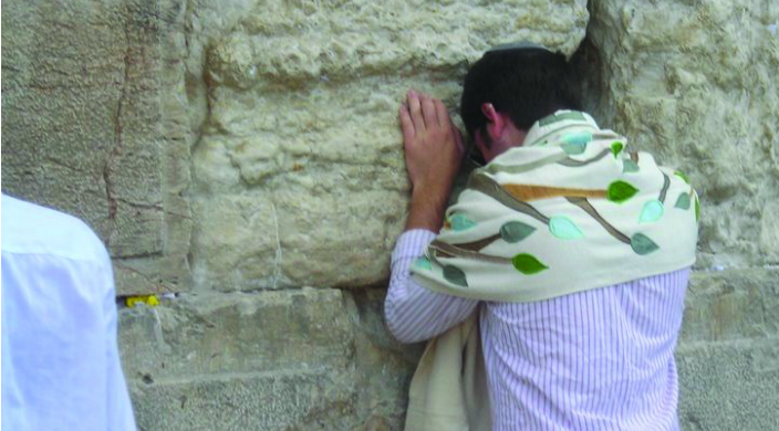 Young person praying intently at the Western Wall in Jerusalem