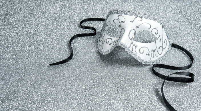 Silvery eye mask with black ties, seemingly discarded