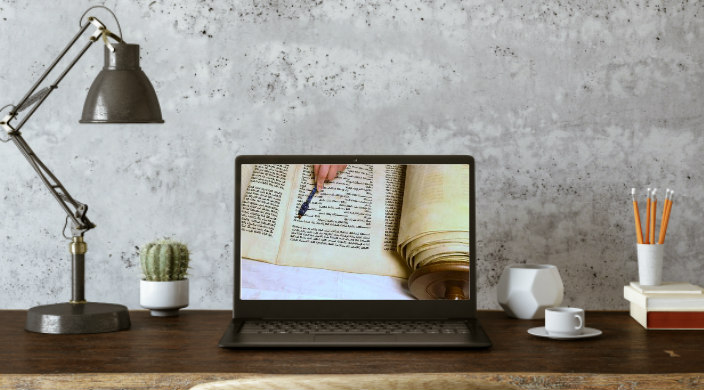 Home desk setup with Torah study displayed on the screen