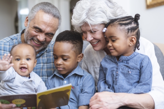 Grandparents reading to three young children 
