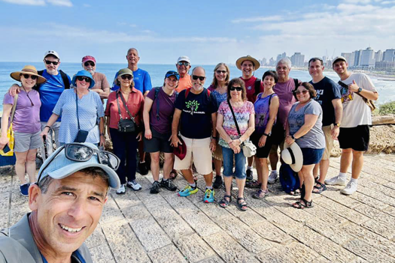 an image of a group of people standing with a lake behind them