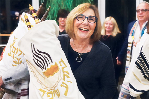 Photo of a woman carrying a Torah