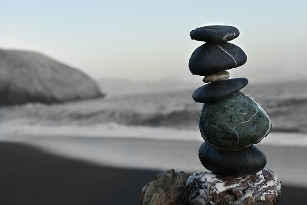 Photo of rocks stacked on the beach next to the ocean