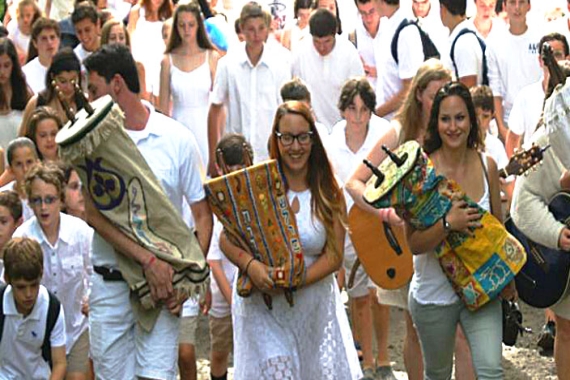 Teens carrying the Torah and wearing white for the Jewish holiday of Shabbat