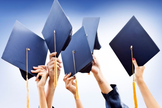 Graduates holding graduation caps