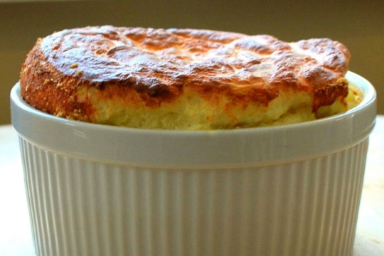 Cheese challah souffle in a white ramekin