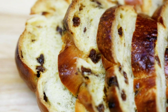 Closeup of a sliced loaf of challah with raisins 