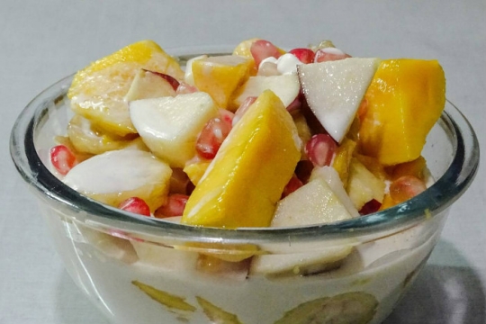Chopped fruits in a white liquid in a clear bowl 