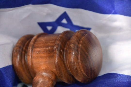 Wooden gavel lying on an Israeli flag