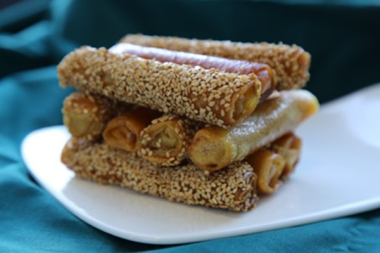 an image of a dish called neulas encanonadas: a pastry confection in the shape of cigars