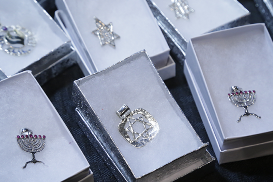 Photo of different necklace charms in the same of Jewish symbols