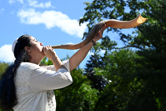 Photo of a person blowing the shofar