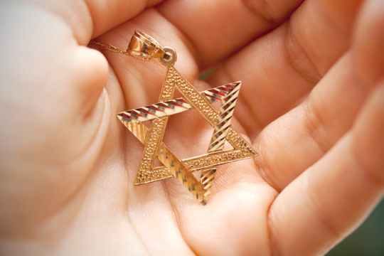 Photo of a hold star of david necklace in a person's hand