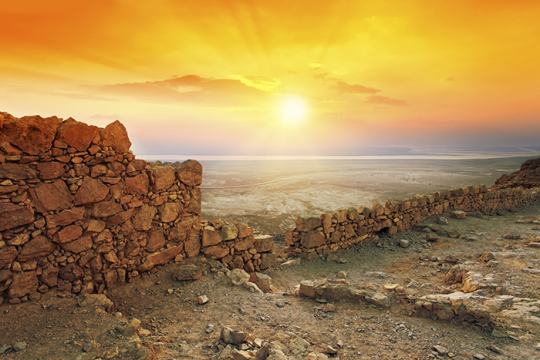 Photo of a sun setting over a desert