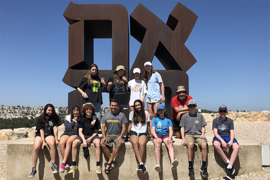 Photo of students posing with the AHAVA sign in Israel