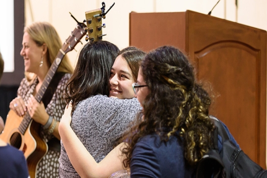 young women giving holiday hugs
