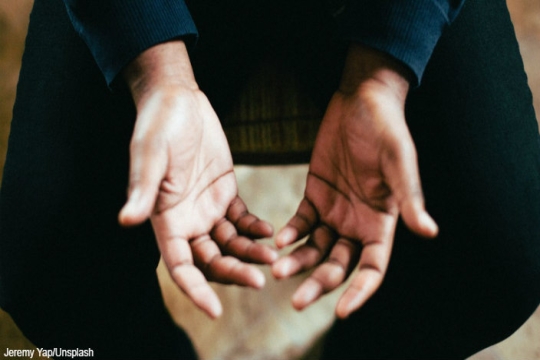 Closeup of upturned hands presumably belonging to a man of color