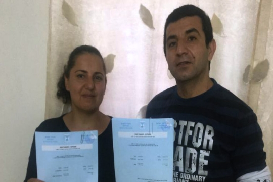Sima and Oded hold the paperwork that made them Israeli citizens