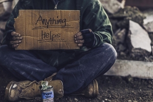 homeless man holding a sign