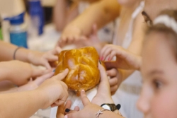 children at jewish summer camp recite the blessing over the challah
