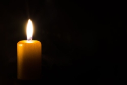 a single candle burning brightly in the darkness