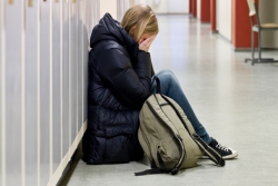 A girl crying in a school hallway