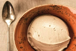 Turkish coffee ice cream in a brown pottery style bowl with a silver spoon