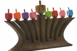 Menorah topped with colorful dreidels where the candles should go