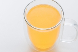 Milky orange drink in a clear mug