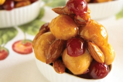 Little bundles of fried dough balls with dried fruit and nuts in a shellacked syrup