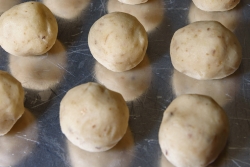 Hand rolled matzah balls on a baking sheet