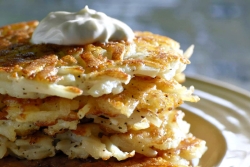 Pile of potato pancakes topped with a dollop of sour cream