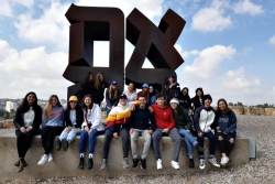 Group of teenage participants in URJ Heller High pose together in front of ahava statue in Israel