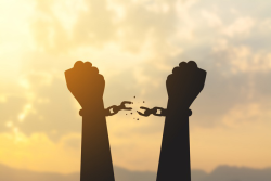 an image of two fists up in the air breaking handcuffs