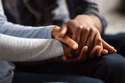 an image of two people holding hands on their laps