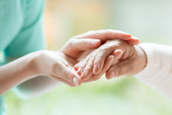 Photo of two younger looking hands embaring an older looking hand