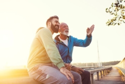 a father and son sitting on a bench
