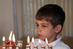 A child lighting the candles with his family for the Jewish holiday of Hanukkah, or Chanukkah