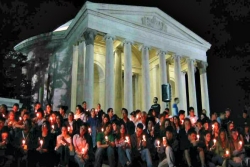 Jewish students sitting on the steps of the Jefferson Memorial in Washington DC by candlelight