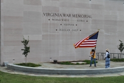 Middle Passage waving American flag in front of the Virginia war memorial