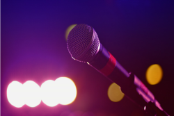 closeup of a microphone with stage lights blurry in the background