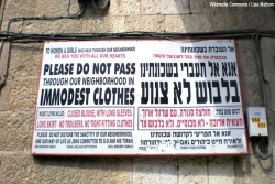 Signs requiring women to dress modestly written in both English and Hebrew in Beit Shemesh