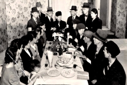 Black and white photo from Yad Vashem showing 1940s Jews observing a seder in the ghetto