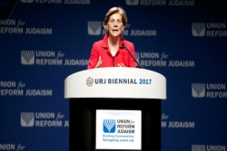 Senator Elizabeth Warren wearing a red blazer against a blue background with the Union for Reform Judaism name and logo 