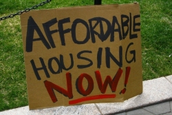 sign reading "Affordable Housing Now"