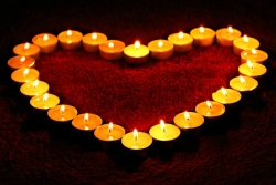 Lit votive candles placed in the shape of a heart