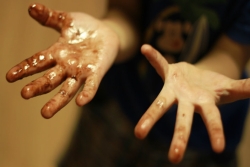 A child's hands, palms up, sticky with chocolate