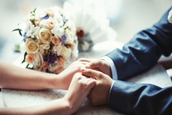 couple holding hands and bouquet of flowers 